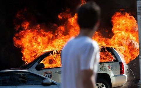 A car burns during clashes between demonstrators and security police in Caracas, capital of Venezuela