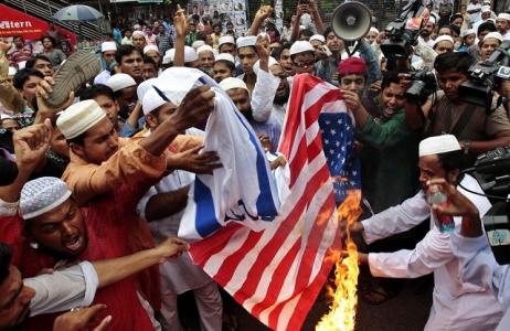 Bangladeshi Muslims burn flags of the U.S. and Israel during a protest against an anti-Islam film which depicts the Prophet Muhammad as a fraud, a womanizer and a madman,  in Dhaka, Bangladesh, Friday, Sept. 14, 2012. (AP Photo/A.M. Ahad)