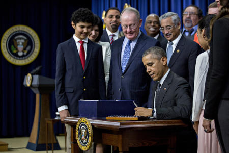 U.S. President Barack Obama signs the Every Student Succeeds Act (ESSA) bill in the South Court Auditorium of the Eisenhower Executive Office Building next to the White House with Kenmore Middle School student Antonio Martin, from left, Senator Lamar Alexander, a Republican from Tennessee, and Representative Bobby Scott, a Democrat from Virginia, in Washington, D.C., U.S., on Thursday, Dec. 10, 2015. The bipartisan ESSA bill cements the progress made in elementary and secondary education over the last seven years and fixes the No Child Left Behind Act to reduce over-testing. Photographer: Andrew Harrer/Bloomberg via Getty Images