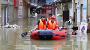 Heavy rains, floods in China strand dozens on rooftops, triggering landslides