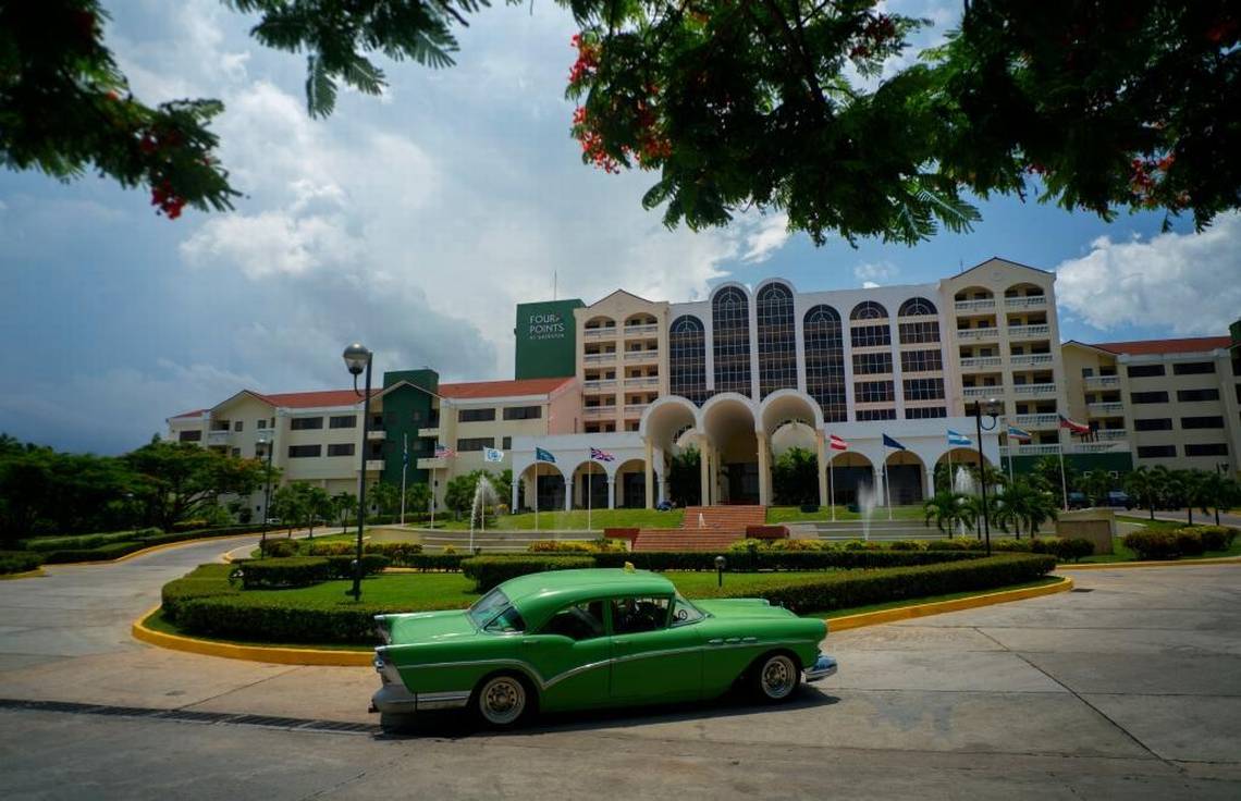In this June 28, 2016 file photo, a vintage car passes in front of the Four Points by Sheraton hotel in Havana, Cuba, managed vy the U.S.-based Starwood hotel chain and owned by Gaviota, part of the military conglomerate known as GAESA.